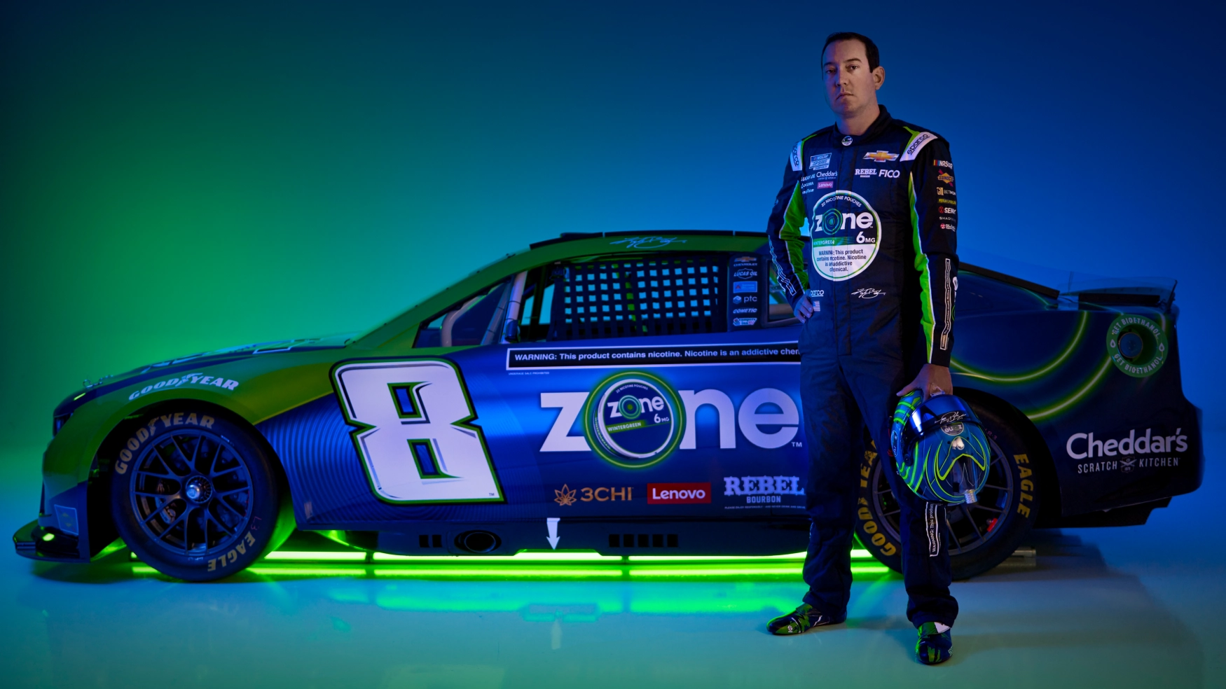 Kyle Busch standing in front of the Zone Nascar Car